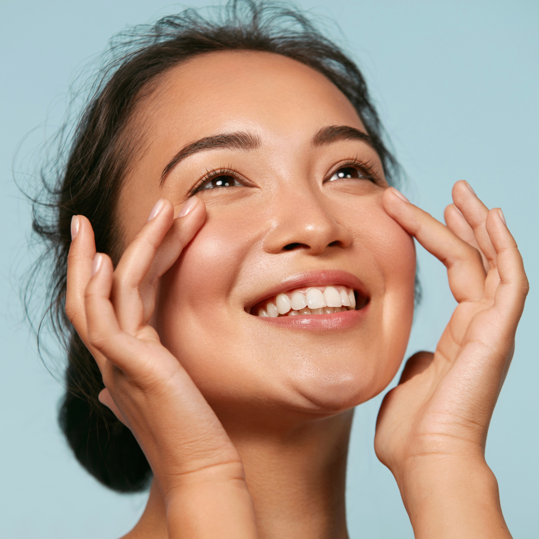 Smiling woman with her hands beside her eyes