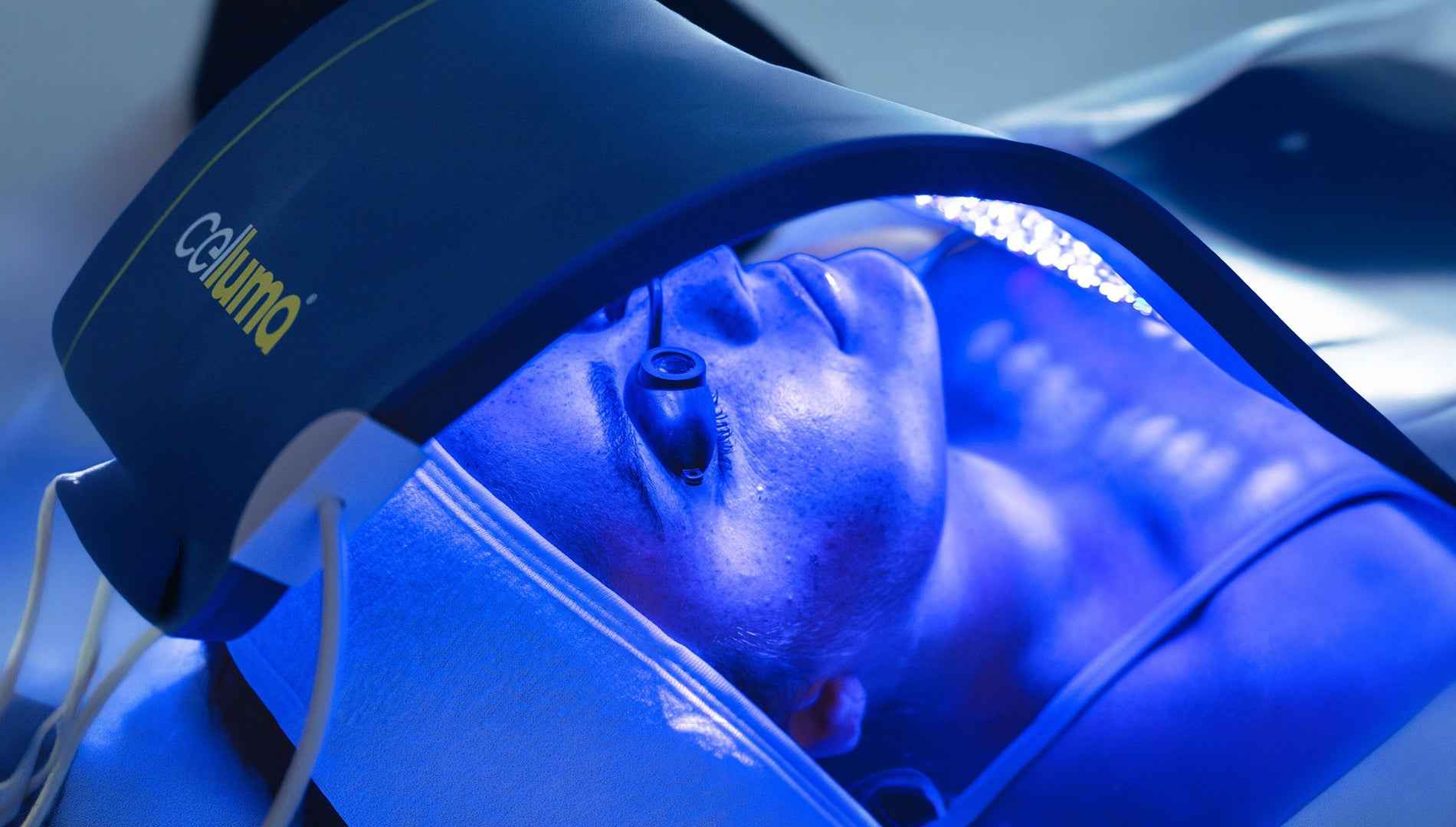 Woman using Celluma PRO Acne mode blue light therapy device for acne treatment