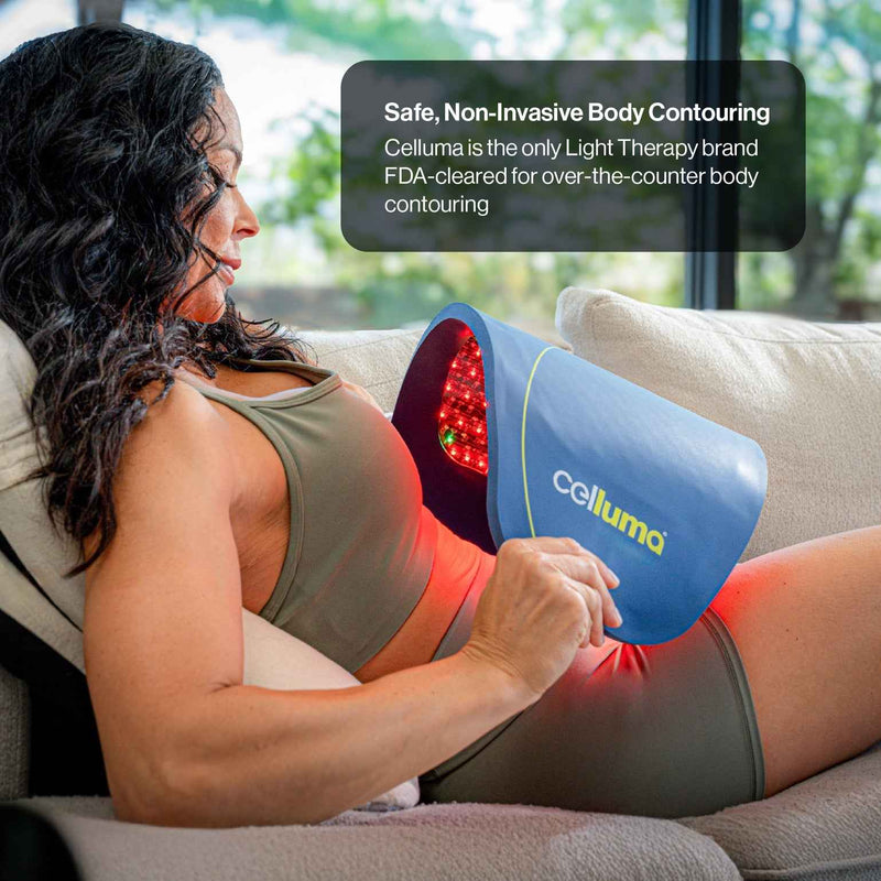 Perempuan duduk dengan panel LED Celluma melengkung di sekitar perut