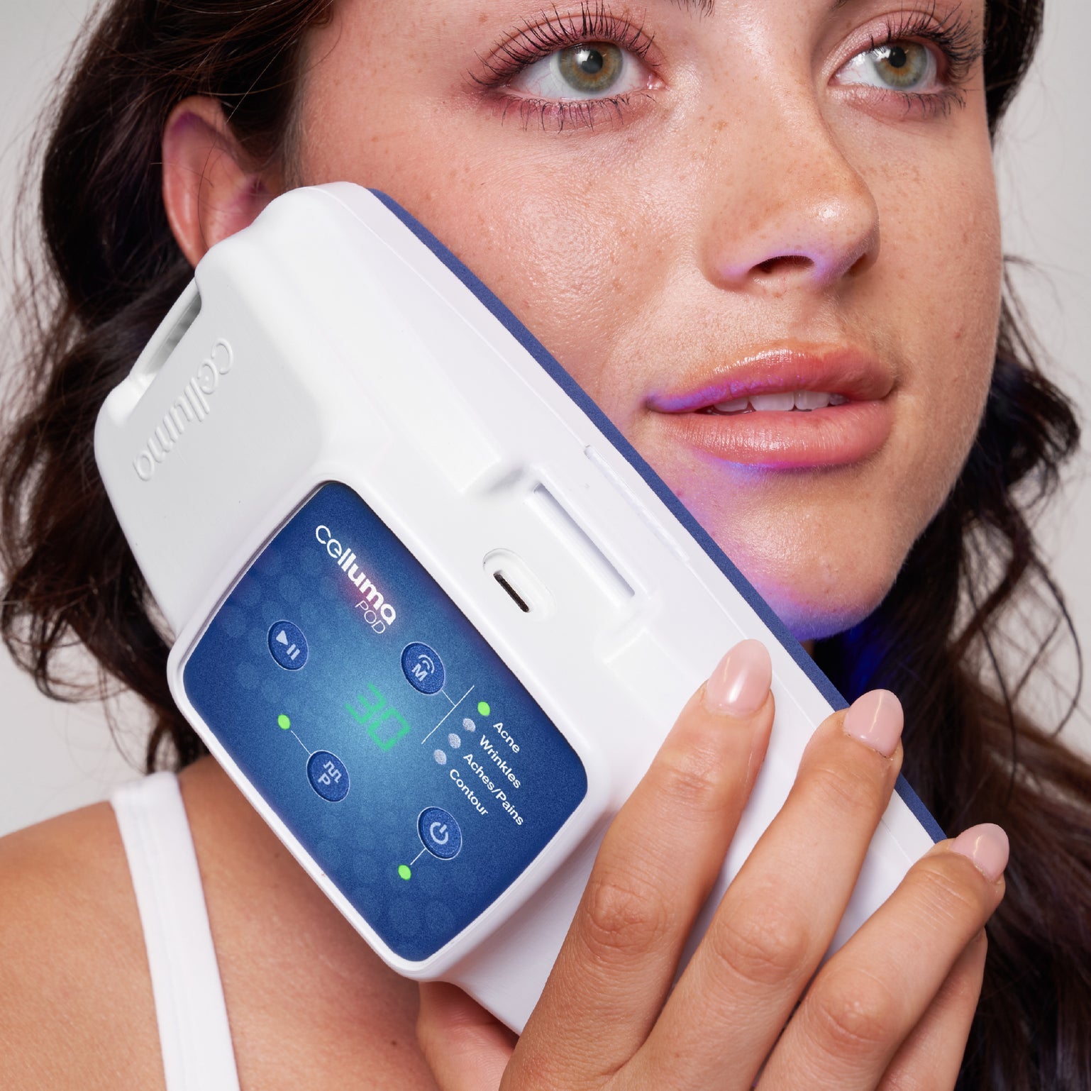 Celluma POD Series 2 handheld LED device treating facial acne. This FDA-cleared 4-mode machine uses 465nm blue light to kill acne-causing bacteria and 640nm red light to reduce inflammation, providing a professional-grade clearing treatment in an ultra-portable design