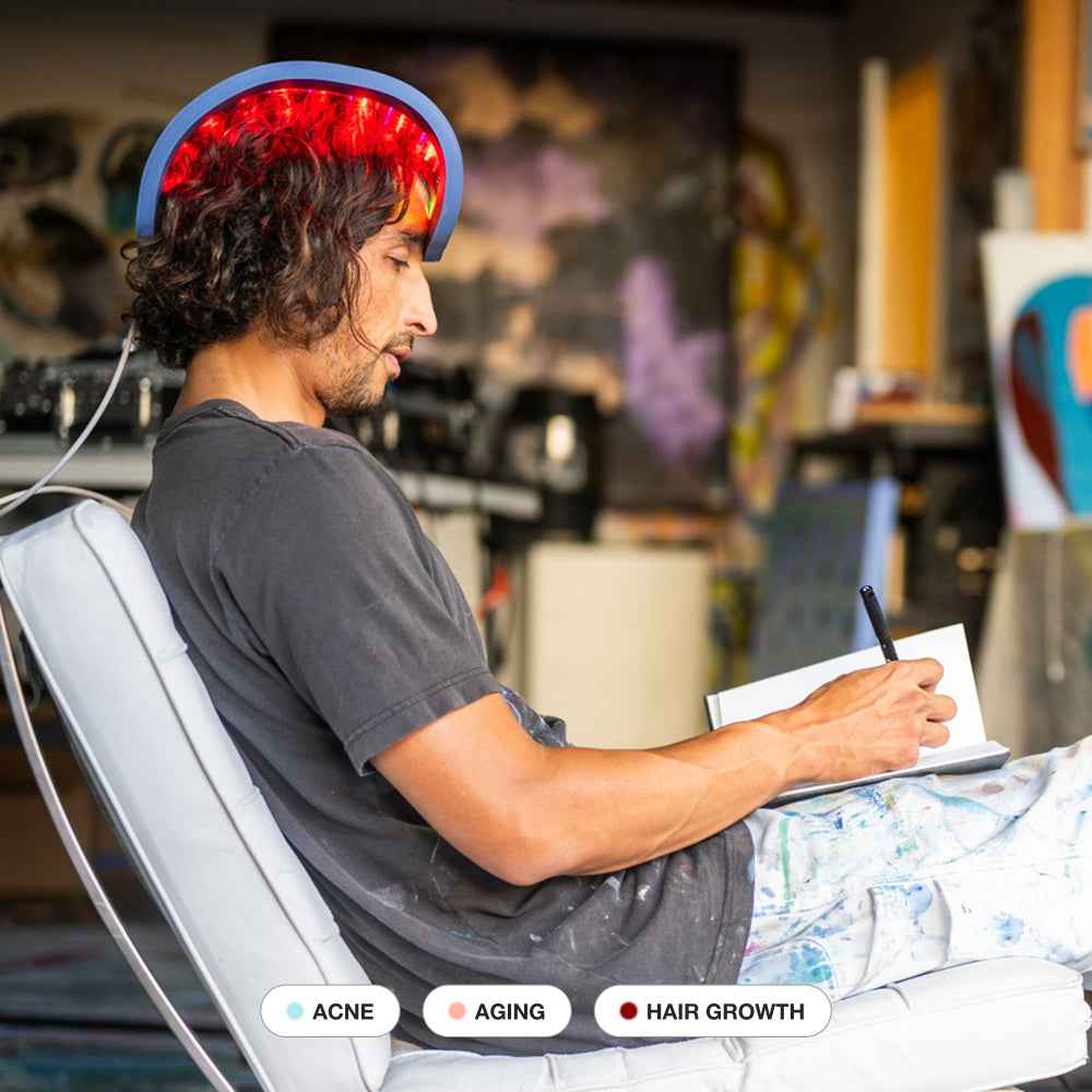 Man using Celluma RESTORE LED Red Light Therapy on his head for hair growth.