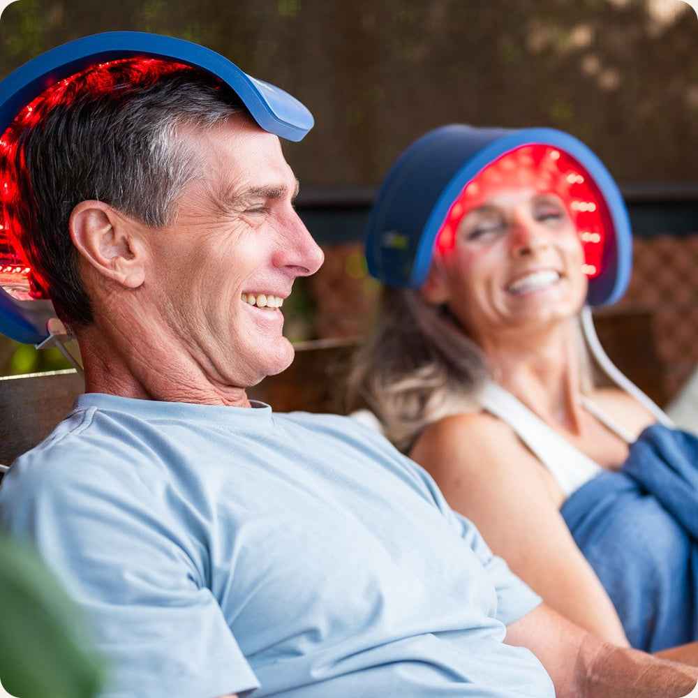 man and woman using Celluma Restore on their head for hair growth.