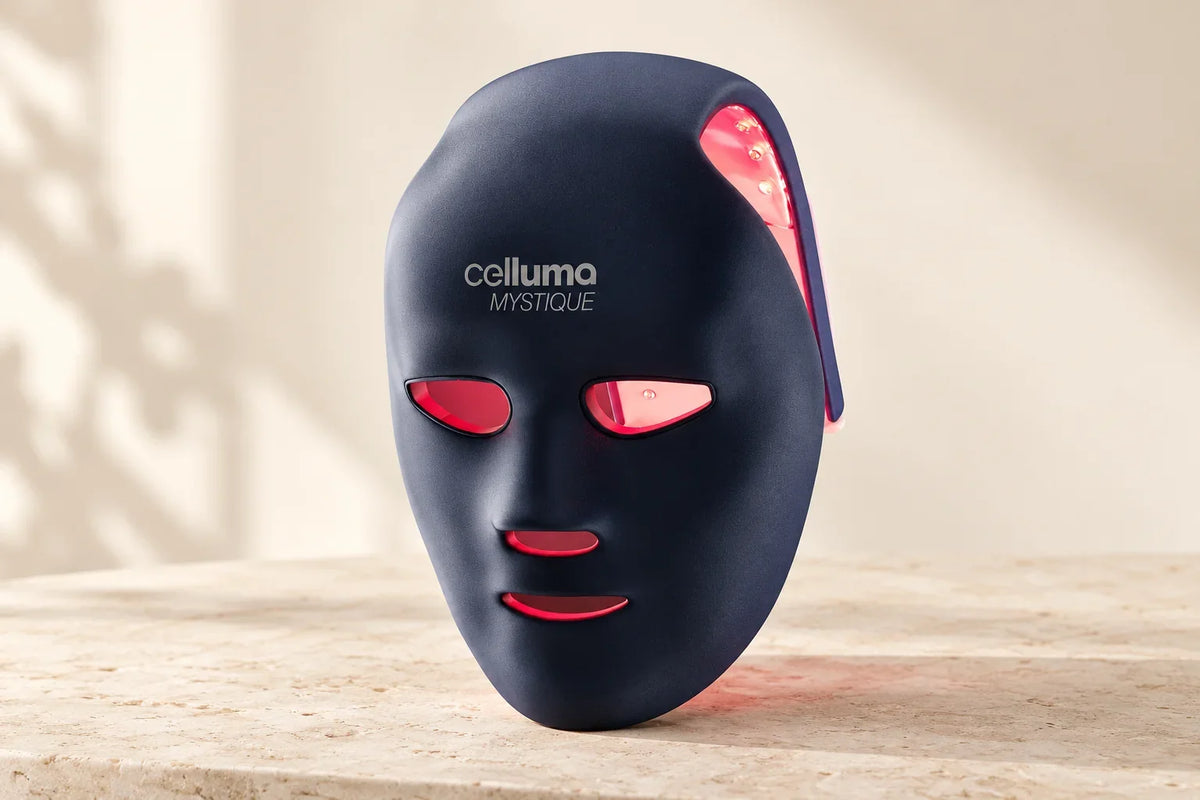 Celluma MYSTIQUE face and scalp light therapy mask with red LEDs on a pale stone surface