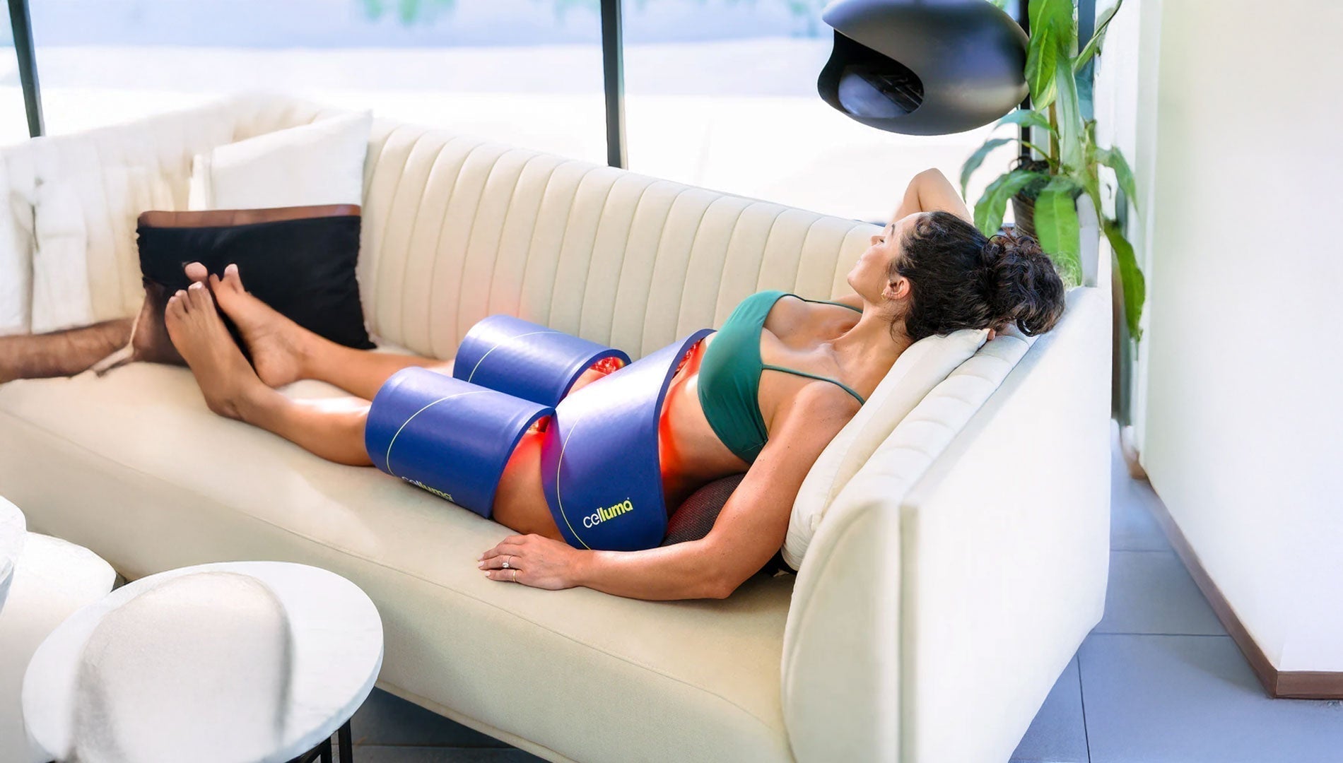 User applying the flexible Celluma CONTOUR panel to the abdominal area for non-invasive fat loss treatment.