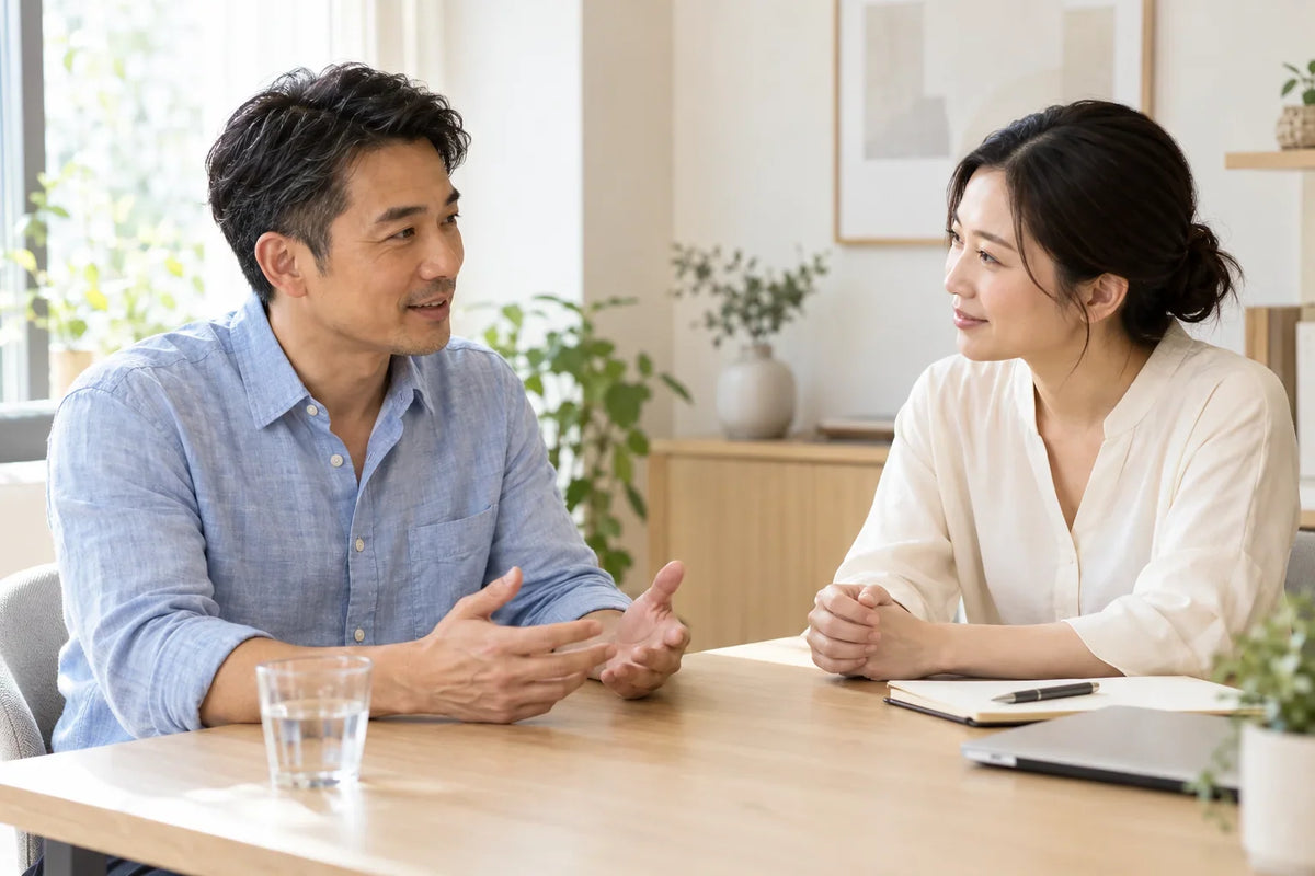 Adult man discussing skin concerns with a skincare professional in a bright, cream consultation room