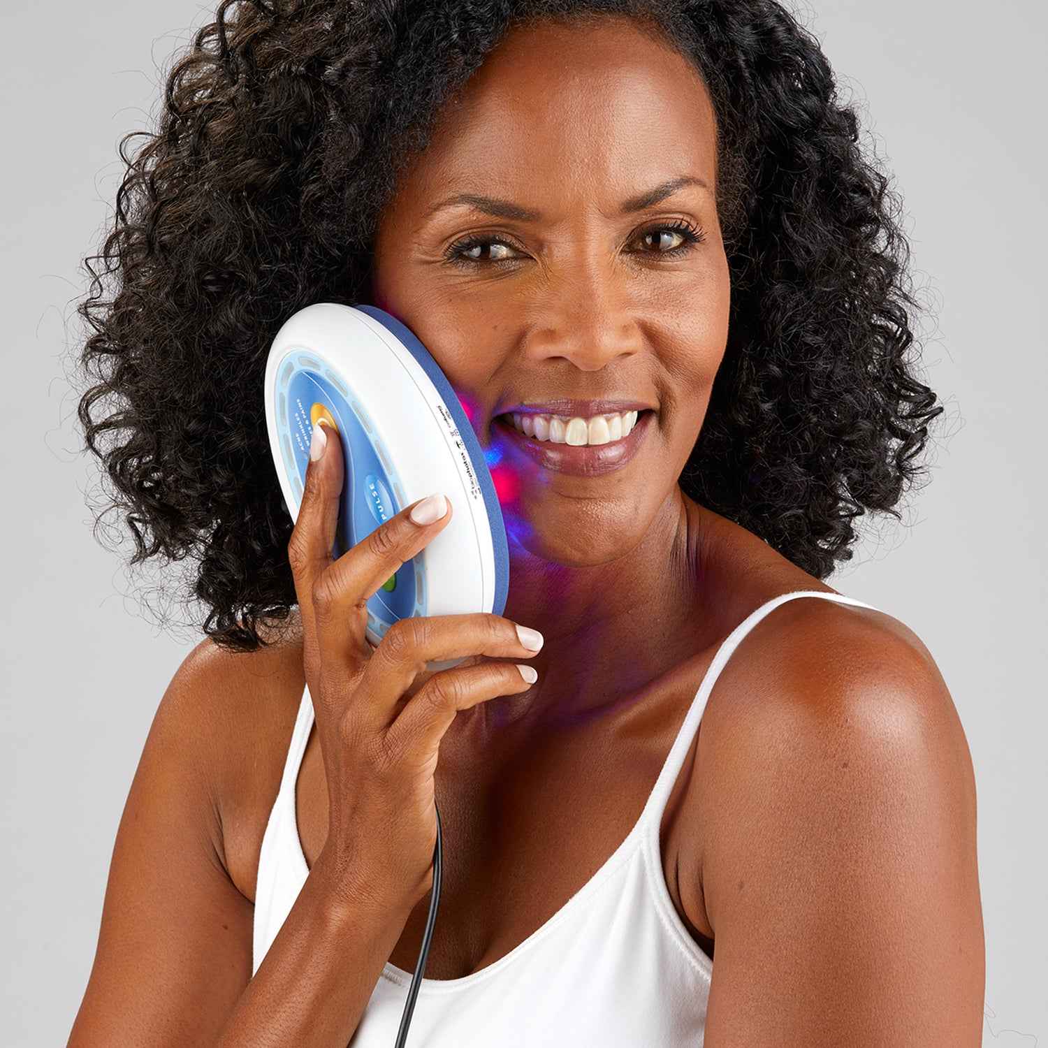 A woman using Celluma POD LED red light therapy to boost collagen on her face.