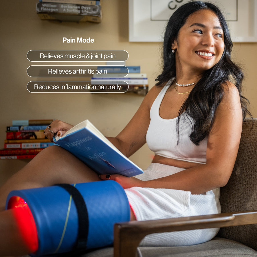 Woman using Celluma LED red light therapy while reading a book, with text about pain relief benefits.