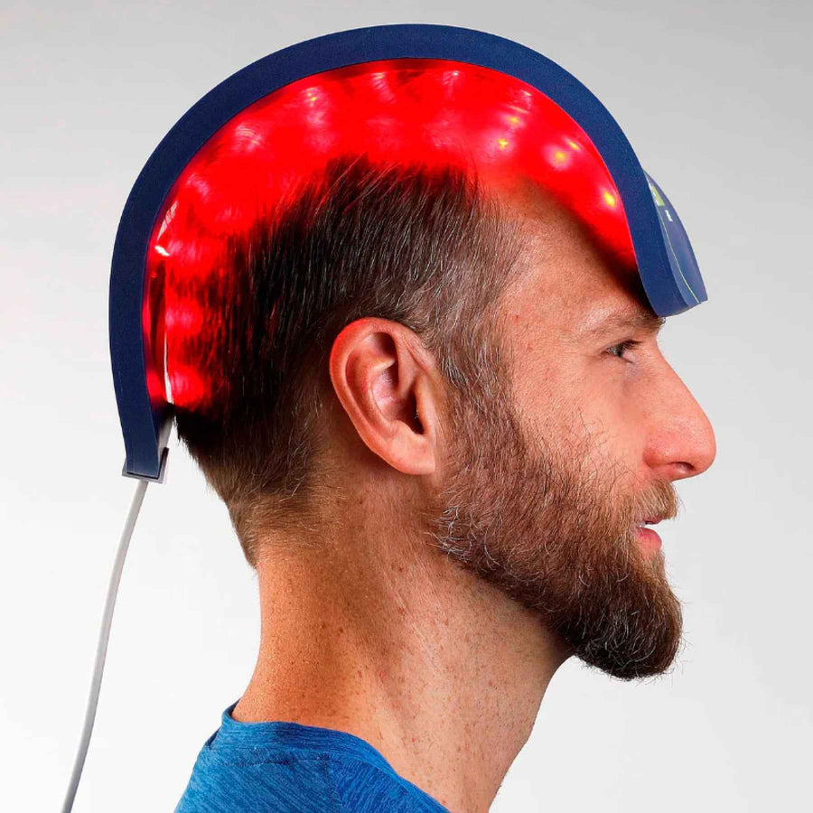 Man wearing a Celluma red light therapy helmet on treating hair loss.