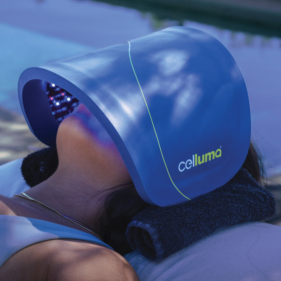 Blue celluma device held by a person with a blurred outdoor background